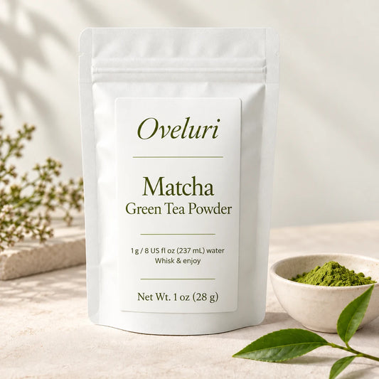 AI packaging concept for Oveluri Matcha Green Tea Powder, 1 oz (28 g): white pouch with an olive italic wordmark, beside matcha powder. Final label and delivered packaging pending supplier approval.