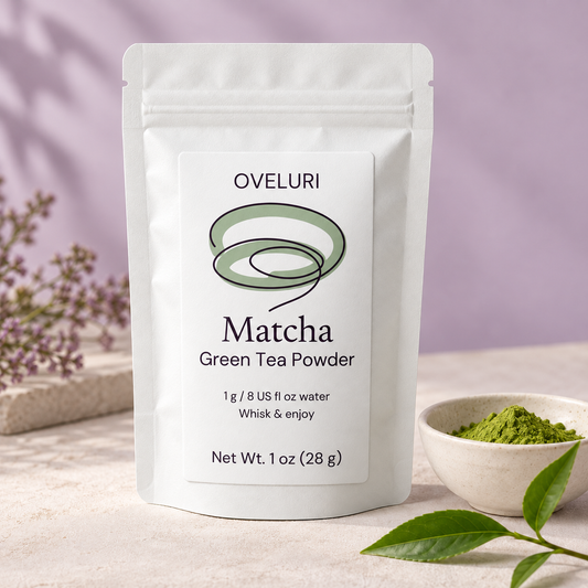 AI packaging concept for Oveluri Matcha Green Tea Powder, 1 oz (28 g): white stand-up pouch with a sage loop label beside a bowl of green powder. Final label and delivered packaging pending supplier approval.